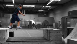 A boy is skateboarding in an indoor skate park.