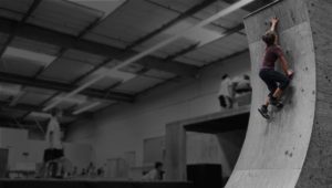 A person on a skateboard doing tricks in an indoor facility.