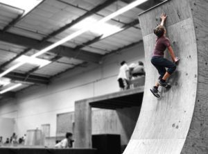 A person on a skateboard up the side of a ramp.