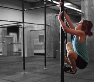 A woman is doing pull ups on a bar