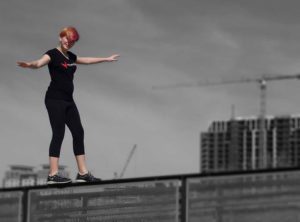 A woman on a skateboard in front of a building.
